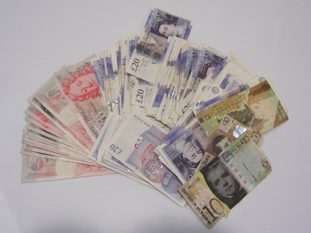 Фото пачки денег веером разбросанных на столе