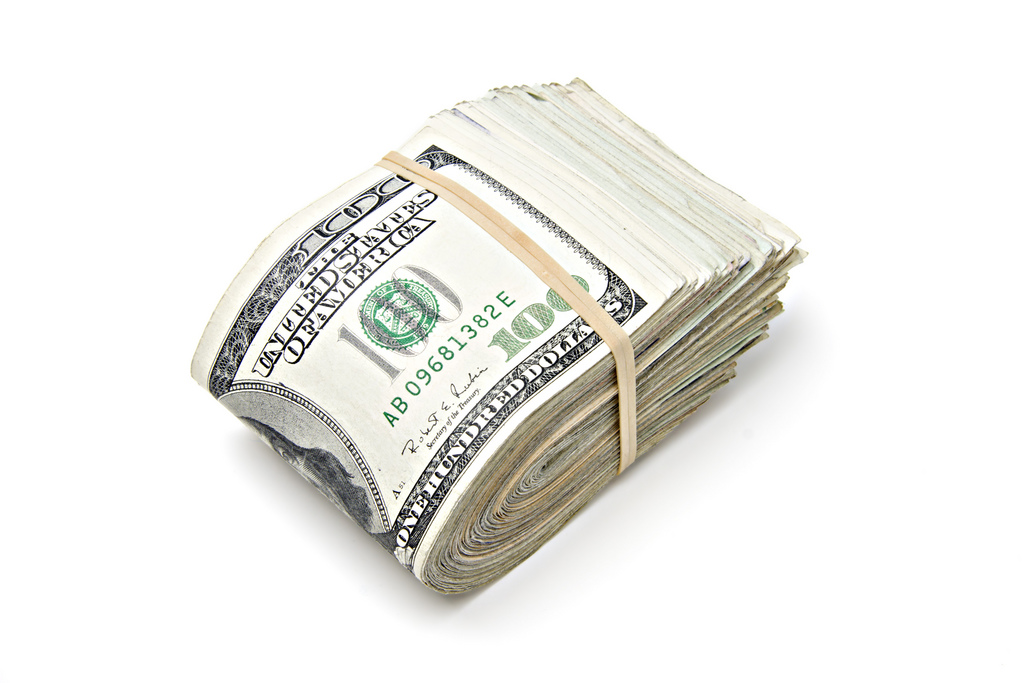 Фото перетянутой резинкой пачки денег (долларов)